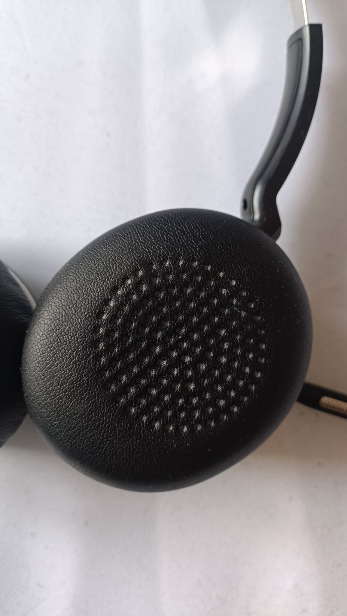 Close-up of Wantek WK882BT ear cushion showing the perforated faux-leather texture and padding thickness