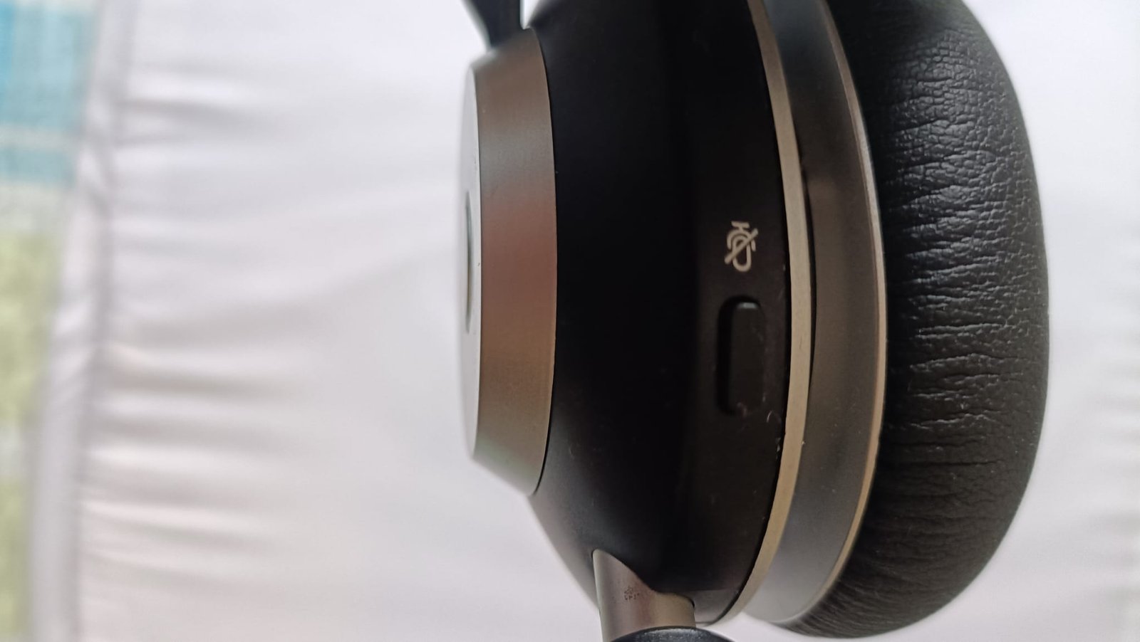 Close-up of the Wantek WK882BT right ear cup outer panel showing the mute microphone icon and physical mute button below it